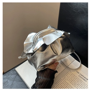 Detail of silver metallic dumpling bag with ruched texture and slim shoulder strap