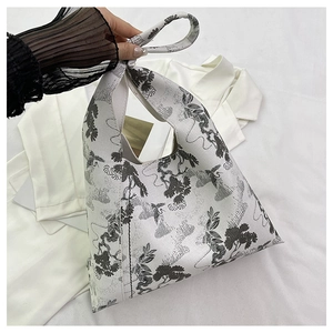 Close-up detail of Chinese ink wash style pine embroidery on a fabric bucket bag