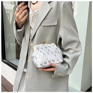 Detail of silver heart-pattern jacquard evening bag with vintage clasp and metal chain