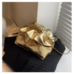 Close-up of golden metallic pleated dumpling bag with drawstring and silver hardware