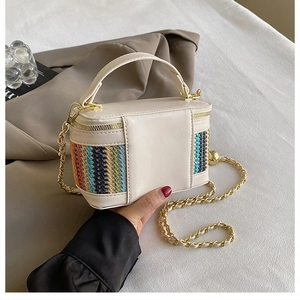 Close-up of woven patchwork box bag with colorful accents and gold chain strap