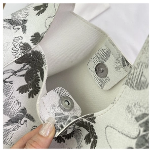 Detailed close-up of interior magnetic clasp and Toile de Jouy print on bucket bag
