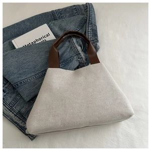 Detail of woven fabric texture and smooth brown handle on a casual bucket bag