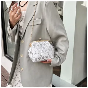 Silver heart-embossed evening bag with metal kiss-lock and elegant gold chain strap