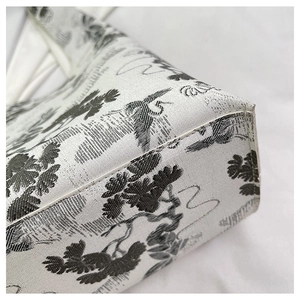 Detailed close-up showing the precise stitching and embroidery of the white tote bag
