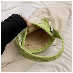 Detailed interior of green corduroy bag showing zipper pocket and textured fabric