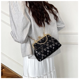 Detail of vintage black kiss-lock bag with silver heart jacquard and gold chain strap