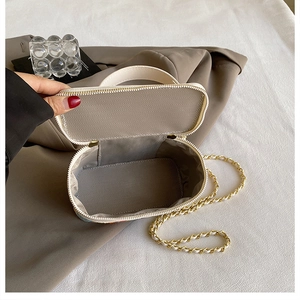 Internal view of the white woven box bag showing the lining and gold chain strap