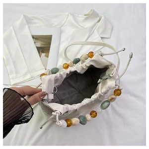 Détail du sac à main blanc à cordon avec bandoulière en perles de résine colorées