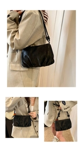 Detalle de bolso nube negro en cuero PU suave con un colgante esférico amarillo