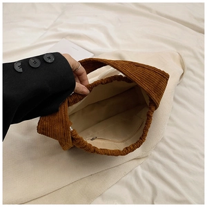 Detail of brown corduroy tote bag showing interior lining and zipped inner pocket