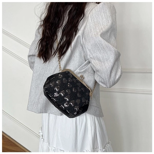 Detail of black heart pattern crossbody bag with gold chain and vintage metal clasp