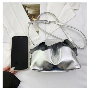 Silver metallic dumpling bag showing size comparison with a large smartphone