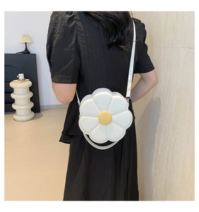 Detailweergave van een witte zonnebloemvormige PU-lederen crossbodytas gedragen door model