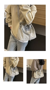 Détail du sac seau en nylon gris avec bandoulières réglables à nœuds et cordon de serrage