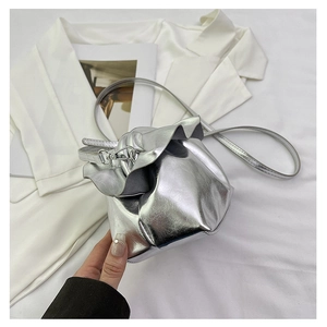 Detail view of silver metallic handbag with unique petal-like pleated trim and slim strap