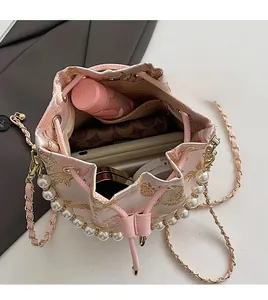 Top view of pink bucket bag showing large interior capacity with embroidery and pearl handle