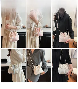 Detail view of floral embroidery silk bucket bag with pearl handle and metal chain strap