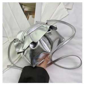 Close-up of metallic silver pleated cloud bag with slim shoulder strap and shiny finish