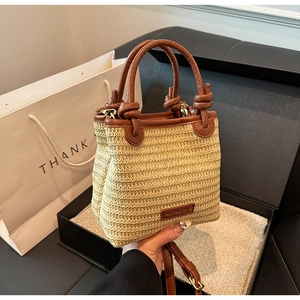 Detail der Strohtasche mit Lederbesatz und runden Griffen in Geschenkbox