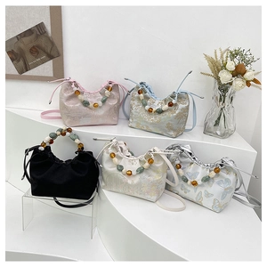 Vue détaillée de divers sacs seaux à fleurs avec des poignées décoratives en perles