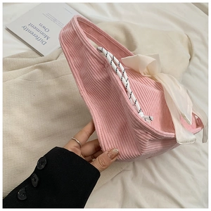 Pink corduroy crescent bag featuring a white silk bow and braided rope handle detail