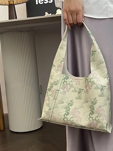 Elegant Chinese style tote bag with green pine and pink flower embroidery held by a model