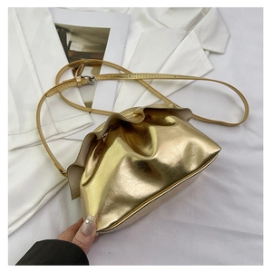 Detail of the golden metallic cloud bag featuring premium pleated texture and thin strap