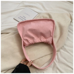 Close-up of pink corduroy fabric texture and curved design of this trendy handbag