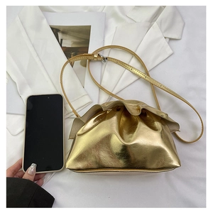 Close-up of metallic gold ruched cloud bag with fine texture and slim crossbody strap