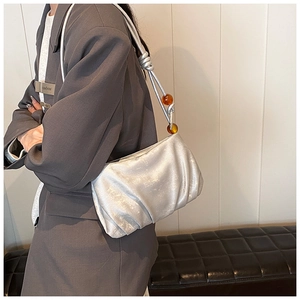 Bolso nube plisado plateado con acabado metálico y detalle de cuentas ámbar en asa