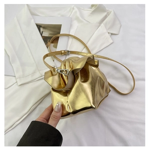 Detail of a metallic gold cloud crossbody bag with stylish pleated faux leather texture
