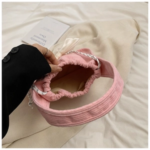 Detail view of pink corduroy drawstring bag interior with lining pocket and woven strap