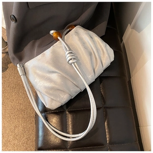 Detalle de bolso nube plateado plisado con cuentas ámbar y correa de nudo