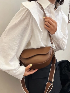 Retro brown saddle bag for women with wide fabric strap shown on model's shoulder