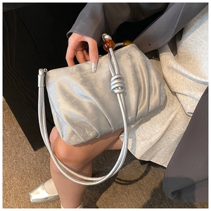 Detalle de bolso nube plateado con nudos de cuentas de ámbar y textura metálica