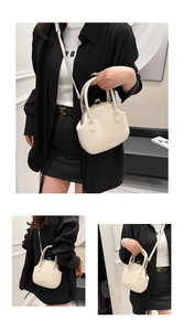 Detail view of cream white shell bag with retro metal clasp and detachable shoulder strap