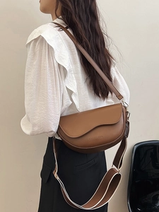 Brown vintage saddle bag with wavy flap design and dual interchangeable shoulder straps