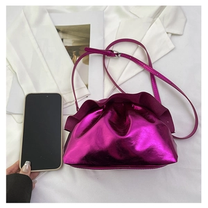 Detail of fuchsia metallic cloud bag with ruffled edges and sleek mirror finish leather