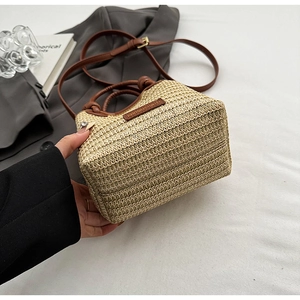 Detail der Strohtasche mit braunen Ledergriffen und sicherem Kordelzug-Innenfutter
