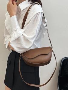 Brown faux leather saddle bag with wave flap design and adjustable straps for women