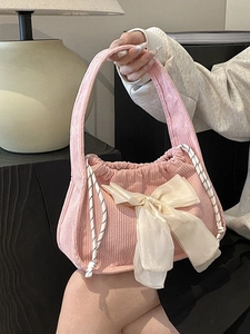Pink corduroy shoulder bag with white silk bow and drawstring closure for women