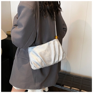 Detalle del bolso nube plisado plateado con textura metálica y detalle de cuenta decorativa