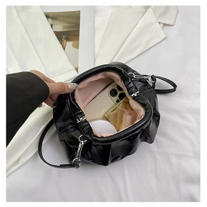 Detail showing inner pink lining and storage capacity for cosmetics in black cloud bag