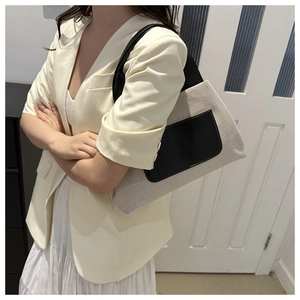 Canvas and leather bucket bag detail worn by a model in a minimalist home setting