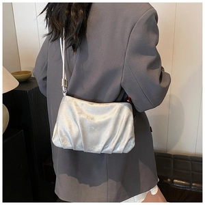 Bolso nube plisado plateado con acabado metálico lucido por modelo en estilo minimalista