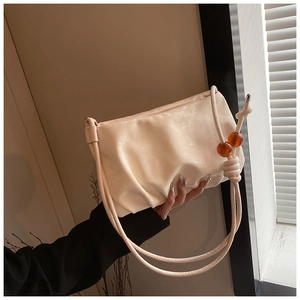 Detalle del bolso nube plisado blanco crema con cuentas de ámbar y correa de hombro fina