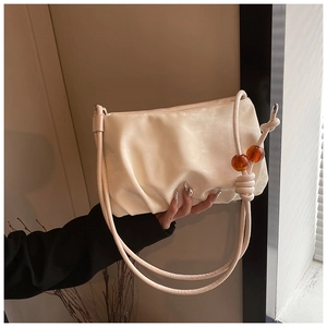 Detalle del bolso nube plisado crema con cuentas de ámbar y correa de nudos