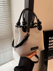 Modische beige Canvas Eimertasche mit schwarzen Lederakzenten und verstellbarem Gurt