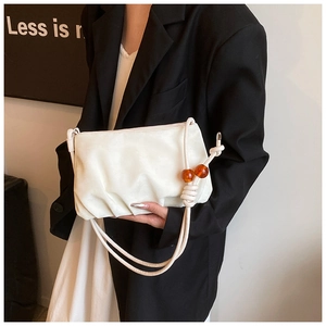 Detalle del bolso nube blanco en cuero plisado con cuentas de ámbar en la bandolera